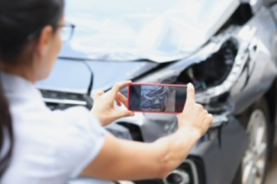 woman-taking-a-picture-of-damaged-car